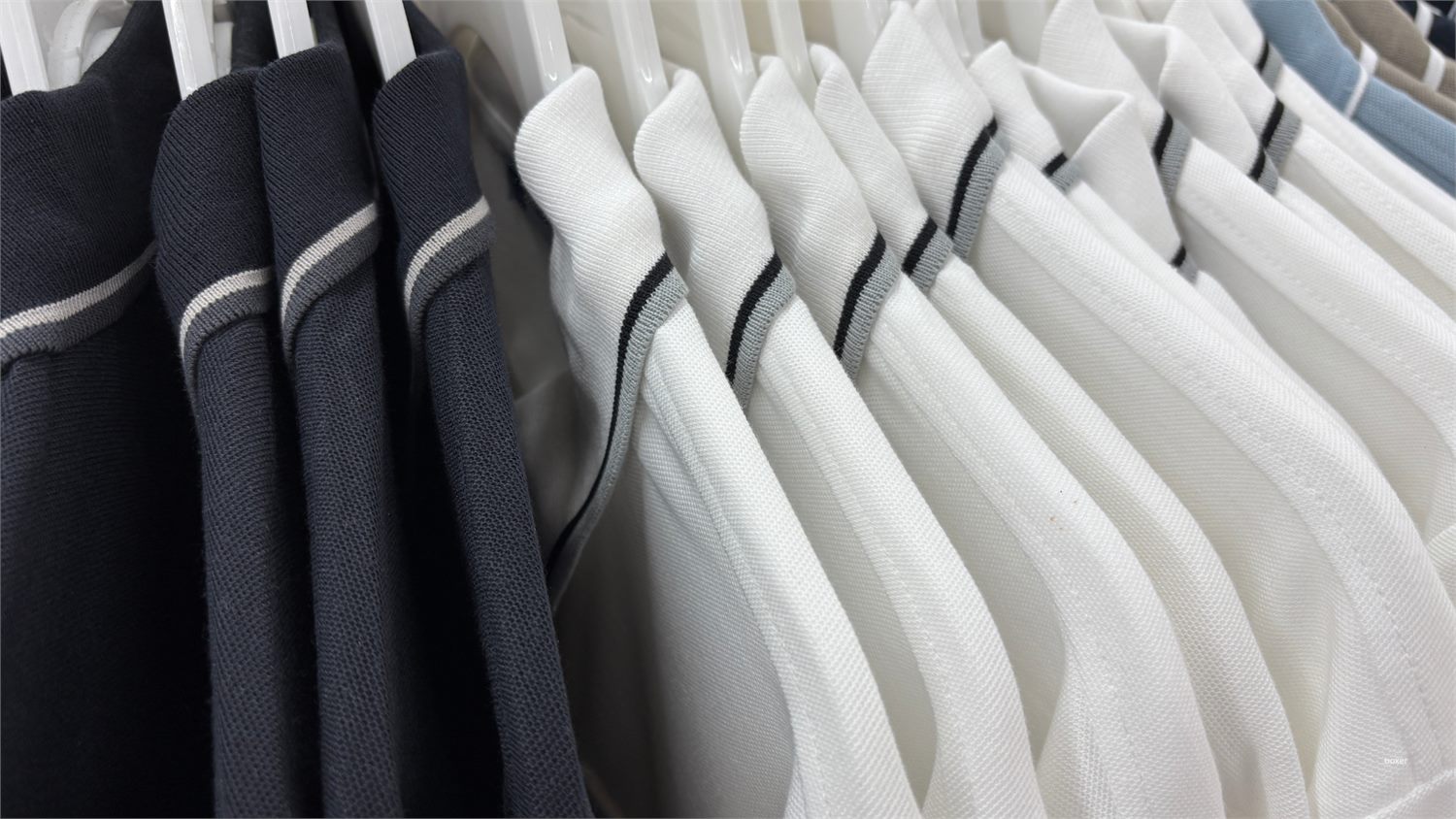 Rows of finished polo shirts hanging on a rack at the Stitch & Style International factory